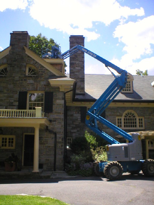 A Cherry Picker being used to repair & refurbish a stone chimney by W.S. Montgomery Chimney and Masonry Services - Philadelphia Area